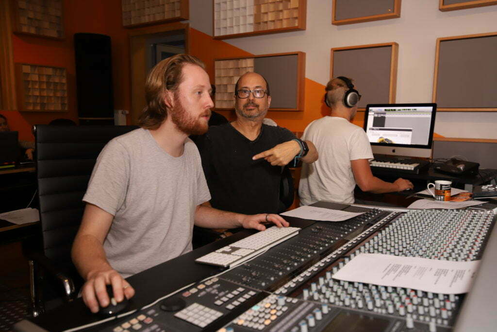 Christoph Thiers and Jeff Bova sitting in front of an SSL mixing console.